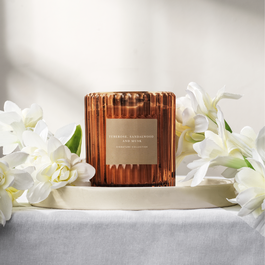 Amber ribbed glass soy wax candle on a white background with flowers