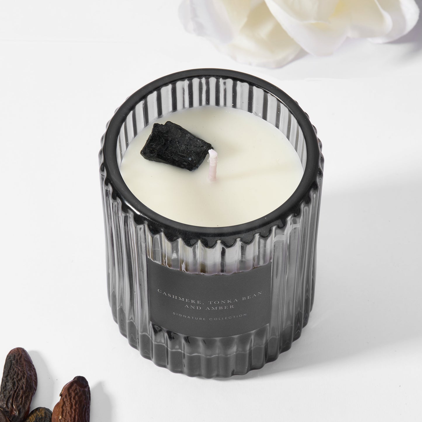 Soy wax candle in black ribbed glass with raw black tourmaline gemstone.