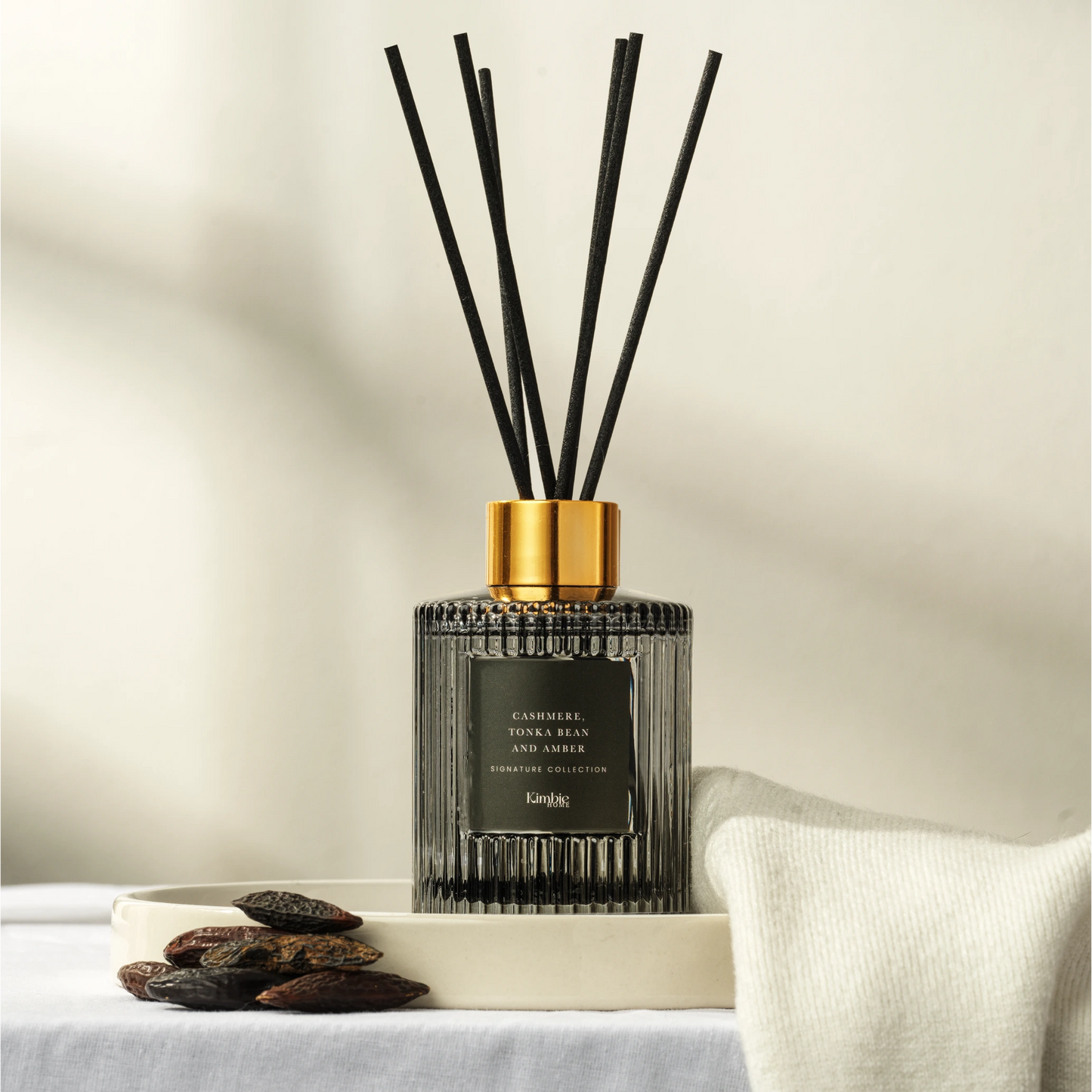 Black natural oil diffuser with black sticks on a neutral background