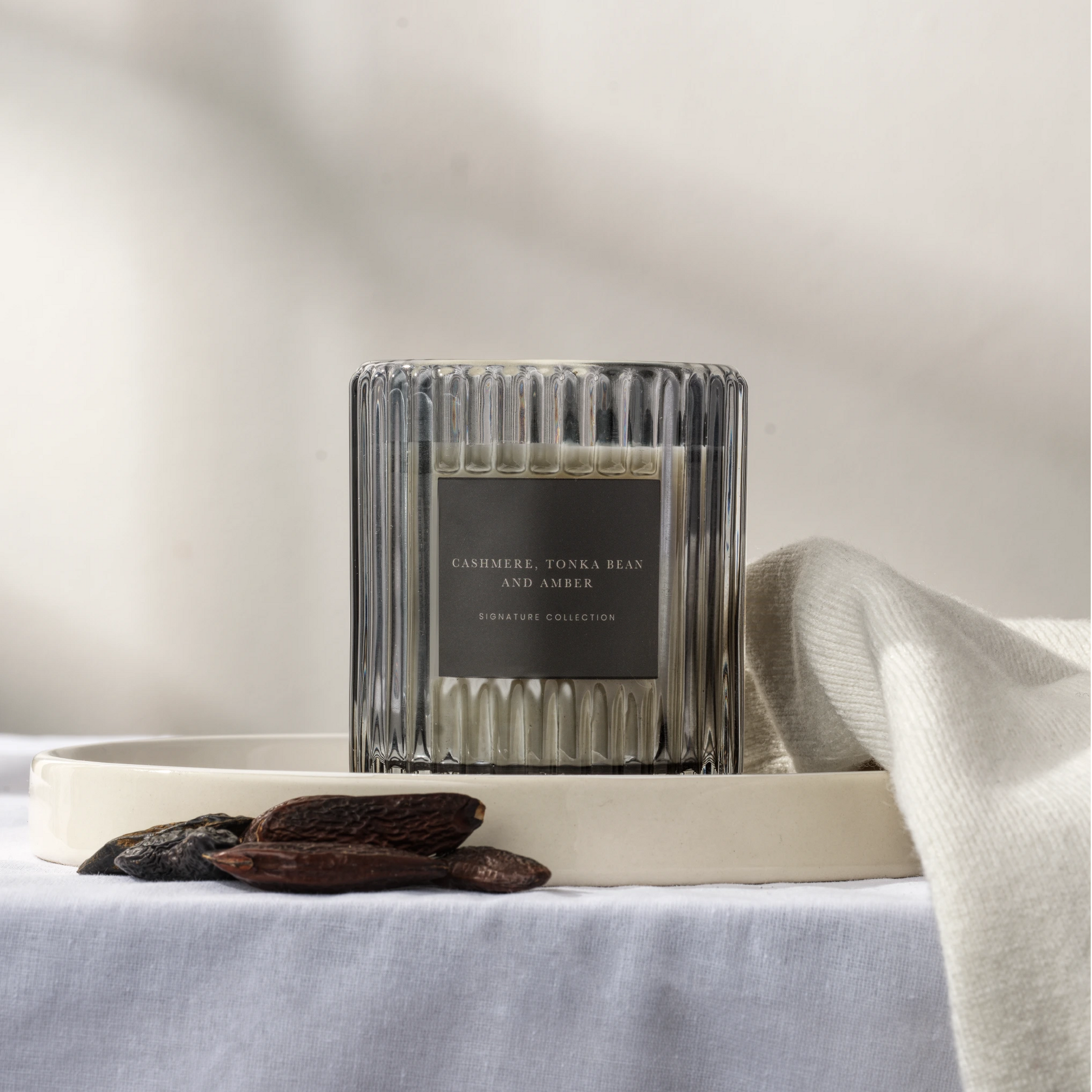 Black ribbed glass soy wax candle on light background