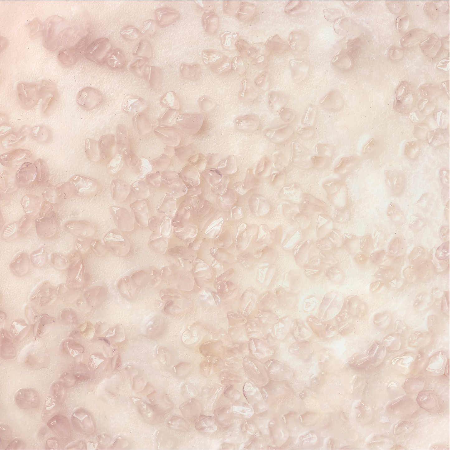 Close-up of small pieces of rose quartz on wax