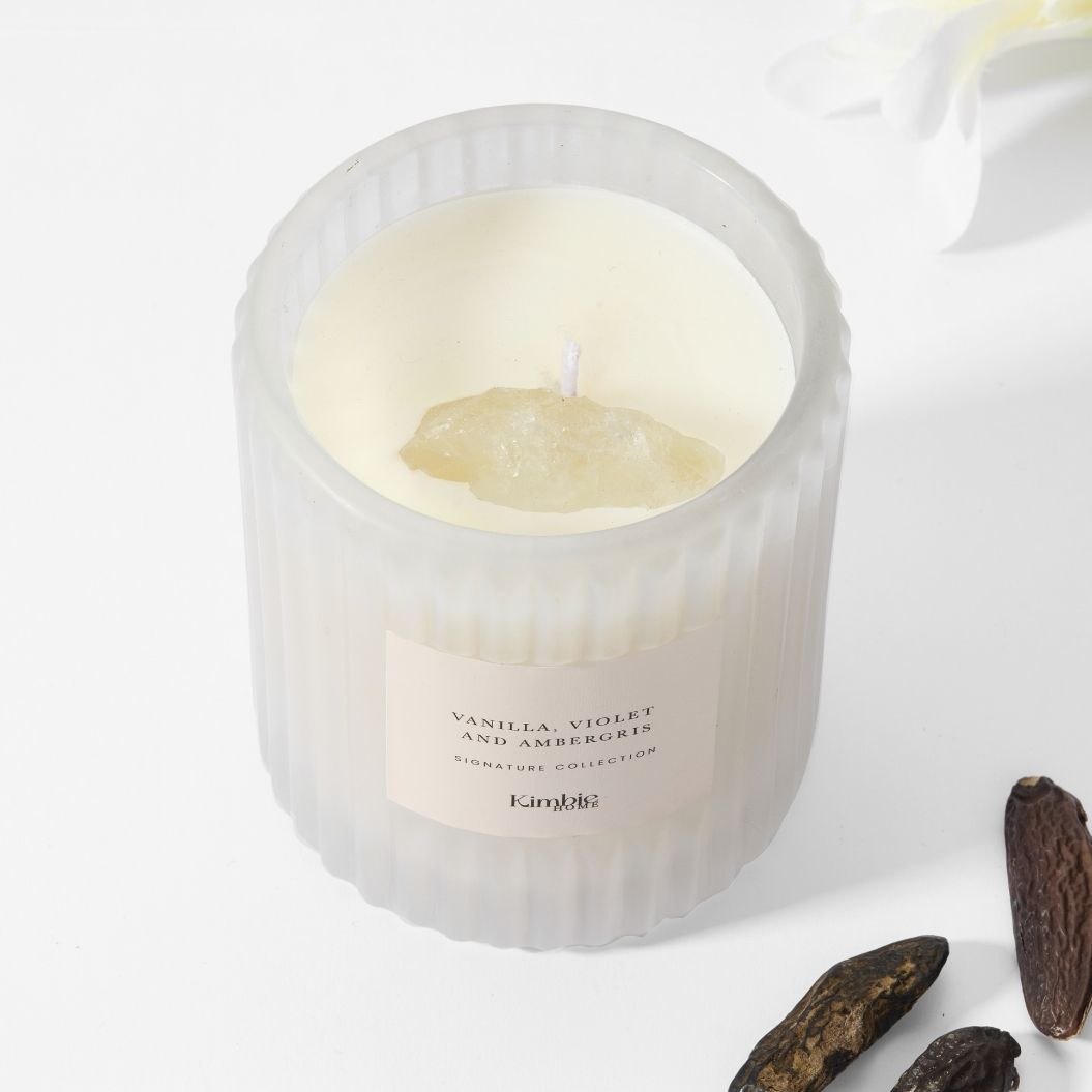 Soy wax candle in white ribbed glass with raw clear quartz gemstone.